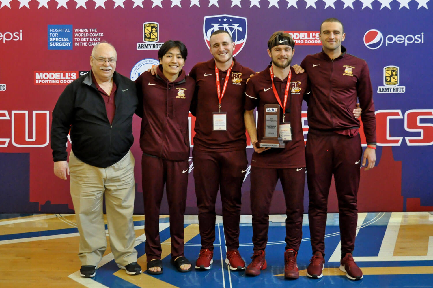 Director of Athletics Bruce Filosa, team captains, and coaches with 2nd Place trophy at CUNYAC Swimming and Diving Championships.
