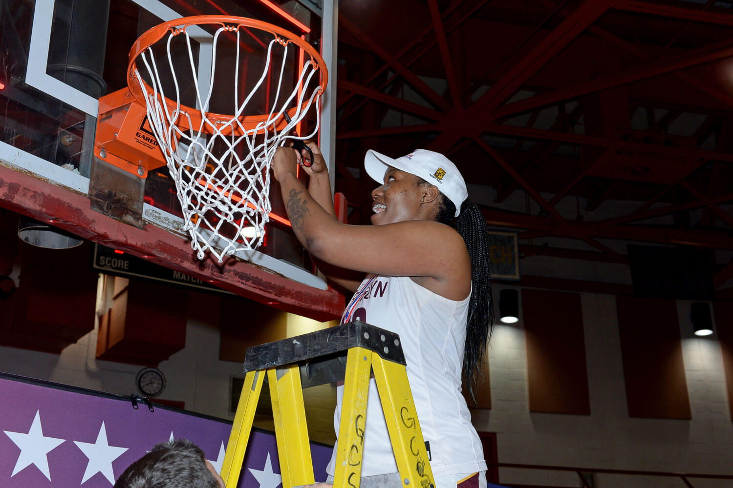 2020 CUNYAC Women's Basketball Tournament MVP, Chanel Jemmott, cutting down the net after Brooklyn's championship victory.