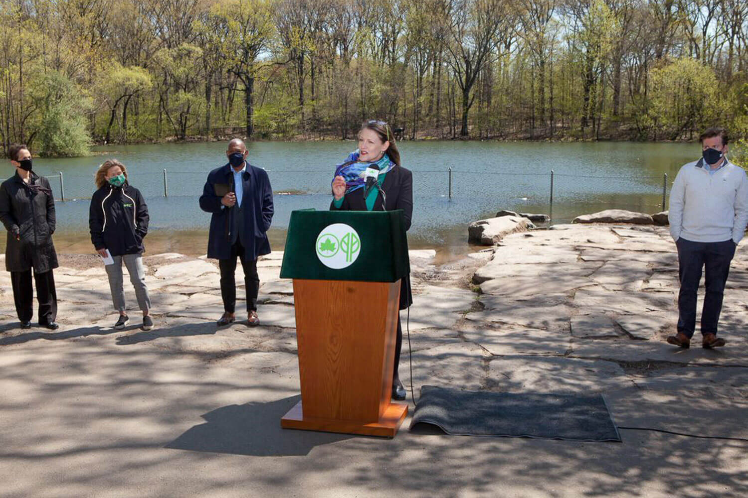 President Michelle J. Anderson addresses the crowd at the April 23 launch of Professor Jennifer Cherrier’s ecoWEIR system that is being used on a pilot project to clean toxic algae from Prospect Park’s water. From left to right are Leslie Wright, New York City Regional Director; Sue Donoghue, President, Prospect Park Alliance; Mitchell J. Silver, New York City Parks Commissioner; and Robert Carroll, New York State Assembly Member.
