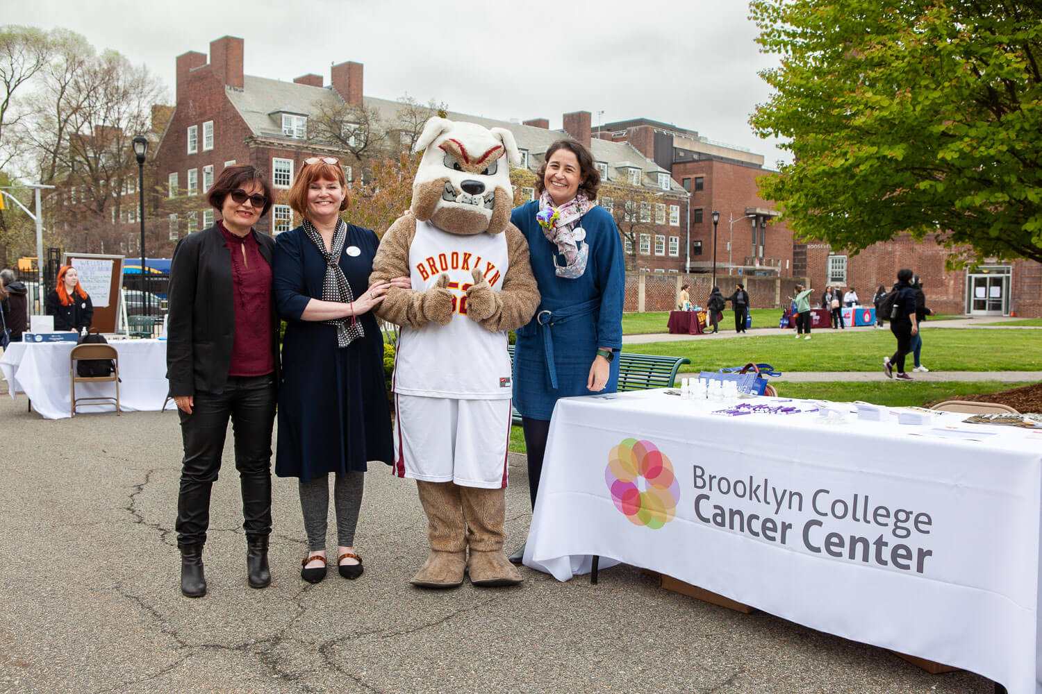 The Brooklyn College Cancer Center held a health and wellness fair in April centered on disease prevention as a tool to support community wellness. Posing with school mascot Buster the Bulldog are (from left to right) Professor Maria Contel, director, BCCC-CURE; Professor Jennifer Basil, associate director of community outreach, BCCC-CURE; and Ana Bartolome, community outreach coordinator and operations manager, BCCC-CURE.